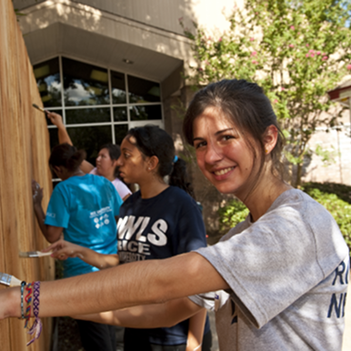 Volunteers painting a fence