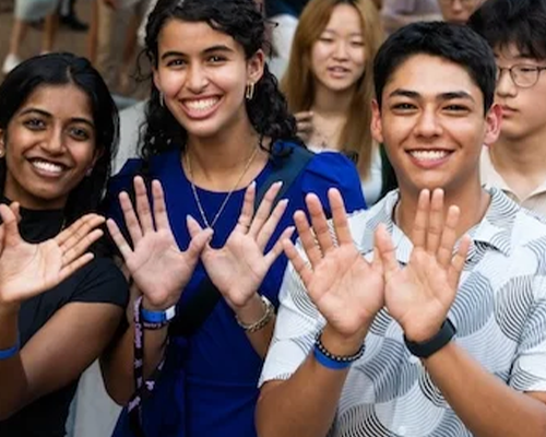 International students making the Owl sign